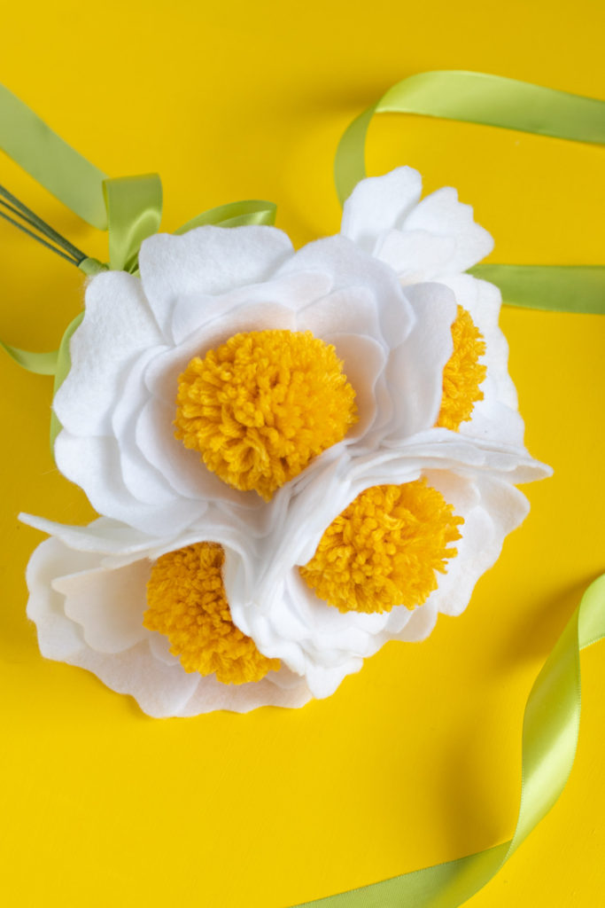 DIY Felt Pom Pom Flowers // Make cute felt flowers with this easy pom pom tutorial! Create beautiful fabric flowers for photo shoots, home decor and parties #paperflowers #pompoms #nosew #feltflowers #diyideas