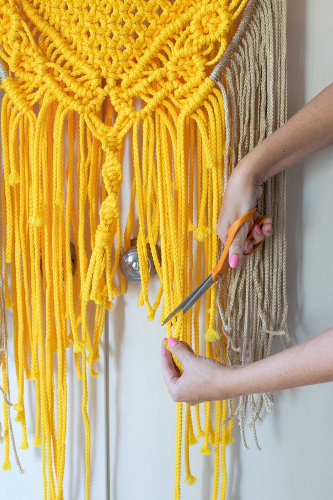 Colorful Macrame Wall Hanging for Beginners // Use simple macrame knots to make a colorful wall hanging with two-tone fringe that's perfect for customizing! #macrame #homedecor #diydecor #wallart #wallhanging #fringe