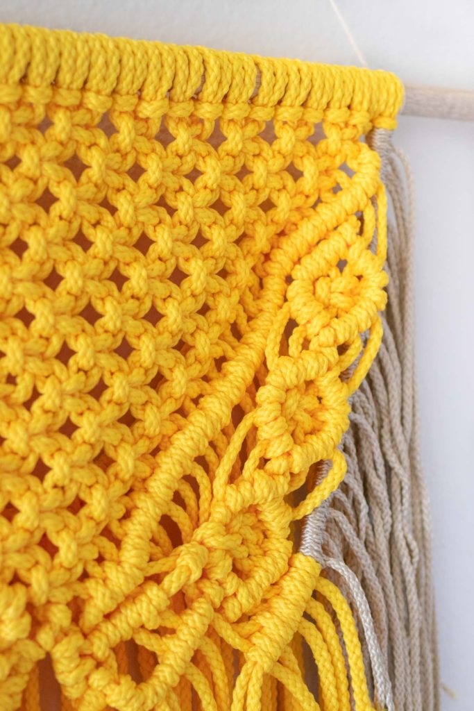Colorful Macrame Wall Hanging for Beginners // Use simple macrame knots to make a colorful wall hanging with two-tone fringe that's perfect for customizing! #macrame #homedecor #diydecor #wallart #wallhanging #fringe