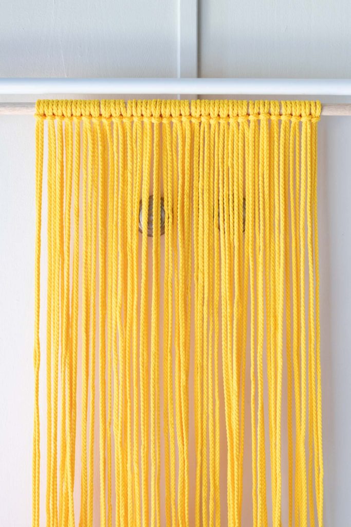 Colorful Macrame Wall Hanging for Beginners // Use simple macrame knots to make a colorful wall hanging with two-tone fringe that's perfect for customizing! #macrame #homedecor #diydecor #wallart #wallhanging #fringe
