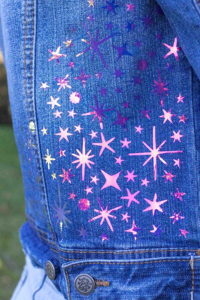 DIY Celestial Holographic Jacket Detail // How to use heat transfer vinyl or holographic iron-on vinyl to make a starry design to update a denim jacket! Download these FREE SVG files for Cricut to make a 90s-inspired holographic denim jacket for the fall // #ad #handmadewithjoann #diystyle #womensfashion #fabricdiy #irononvinyl #holographic #iridescent #freetemplate