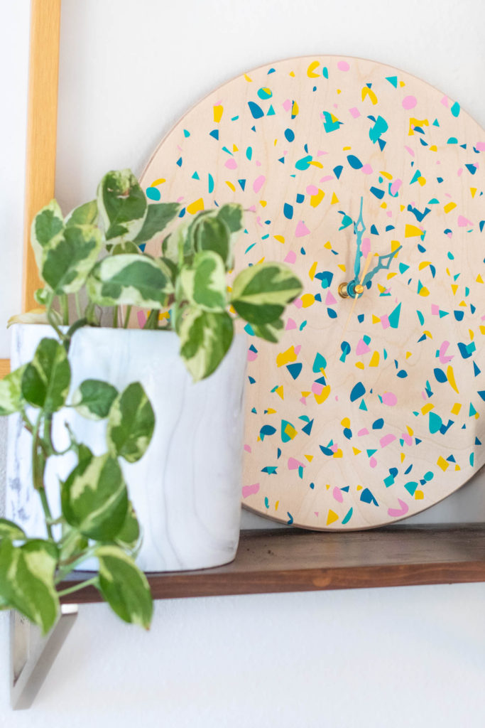 DIY Terrazzo Clock with Vinyl (Free SVG Template!) // Use your Cricut or Silhouette machine to add a colorful terrazzo pattern to a wooden clock with @joann branded adhesive vinyl packs! Simply cut and layer for a unique pieces of wall art using this free cut template! #handmadewithjoann #vinyl #freetemplate #wallart #homedecor #diydecor #terrazzo #cricutmade
