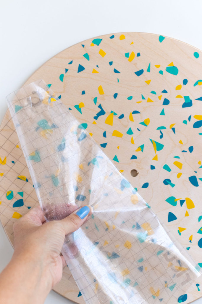 DIY Terrazzo Clock with Vinyl (Free SVG Template!) // Use your Cricut or Silhouette machine to add a colorful terrazzo pattern to a wooden clock with @joann branded adhesive vinyl packs! Simply cut and layer for a unique pieces of wall art using this free cut template! #handmadewithjoann #vinyl #freetemplate #wallart #homedecor #diydecor #terrazzo #cricutmade