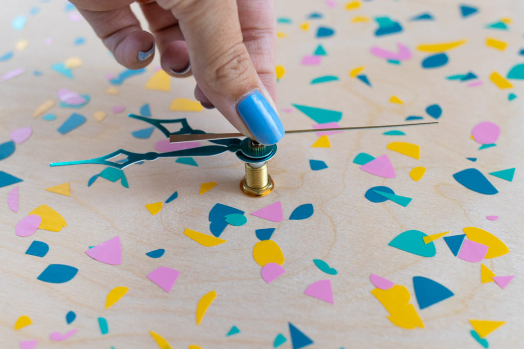 DIY Terrazzo Clock with Vinyl (Free SVG Template!) // Use your Cricut or Silhouette machine to add a colorful terrazzo pattern to a wooden clock with @joann branded adhesive vinyl packs! Simply cut and layer for a unique pieces of wall art using this free cut template! #handmadewithjoann #vinyl #freetemplate #wallart #homedecor #diydecor #terrazzo #cricutmade