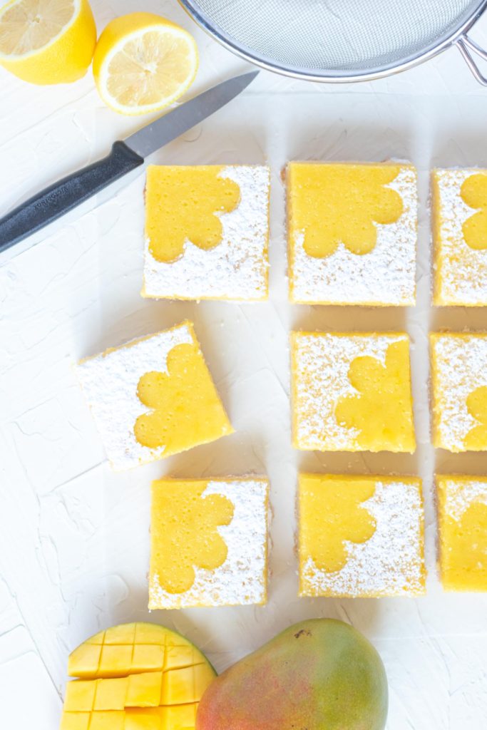 Tart Lemon Mango Bars // Perfectly tart and sweet mango bars with a shortbread cookie crust are the perfect way to celebrate the summer and bring for parties and potluck snacks! Make with fresh mango puree and lemon juice, they're sweet with the perfect amount of bite #mango #fruitbars #shortbread #summertreat #summerrecipes #summerdessert