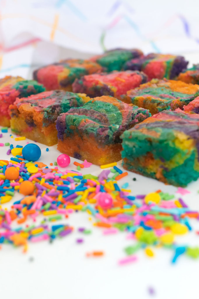 Rainbow Tie Dye Blondies // Get ready to celebrate anything and everything with rainbow blondies that have a colorful tie dye look! 90s kids will love these tie dye blondies made with white chocolate. After all, rick chewy blondies are at least as good as brownies! #brownies #blondies #recipes #whitechocolate #rainbow #tiedye #rainbowfoods #dessertrecipes #colorfuldessert