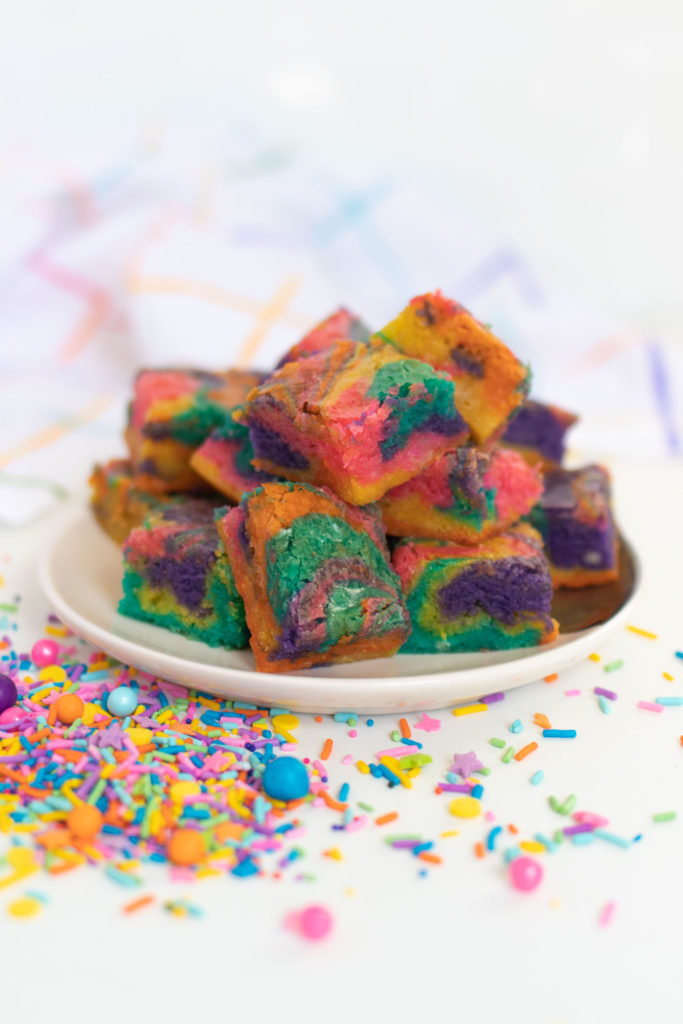 Rainbow Tie Dye Blondies // Get ready to celebrate anything and everything with rainbow blondies that have a colorful tie dye look! 90s kids will love these tie dye blondies made with white chocolate. After all, rick chewy blondies are at least as good as brownies! #brownies #blondies #recipes #whitechocolate #rainbow #tiedye #rainbowfoods #dessertrecipes #colorfuldessert