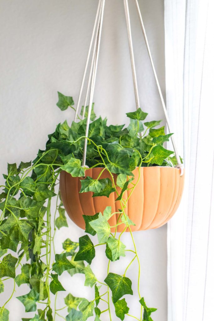 DIY Hanging Pumpkin Planter for Fall // See how to cut a fake pumpkin to make a hanging planter to decorate your home for fall! Fill it with your favorite faux plants or give one as a gift! #pumpkins #homedecor #falldecor #falldiy #halloweendiy #planter #plantlady #fakepumpkins #pumpkincarving