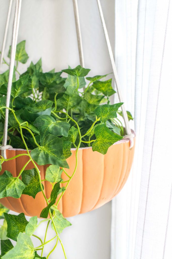 DIY Hanging Pumpkin Planter for Fall // See how to cut a fake pumpkin to make a hanging planter to decorate your home for fall! Fill it with your favorite faux plants or give one as a gift! #pumpkins #homedecor #falldecor #falldiy #halloweendiy #planter #plantlady #fakepumpkins #pumpkincarving