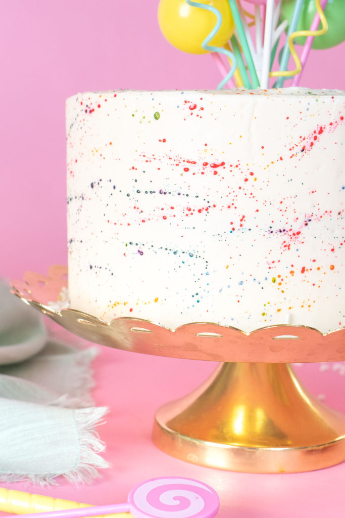 Colorful Splatter Cake // Decorate your favorite cake with splattered food coloring for a fun take on splatter paint designs popular in the 1980s and 90s, perfect for birthdays and other celebrations! #cakedecorating #cake #cakeideas #birthdaycake #birthday #painting #90s #80s