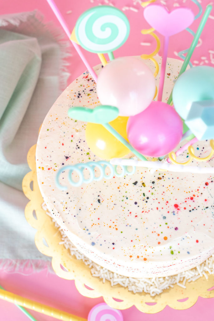 Colorful Splatter Cake // Decorate your favorite cake with splattered food coloring for a fun take on splatter paint designs popular in the 1980s and 90s, perfect for birthdays and other celebrations! #cakedecorating #cake #cakeideas #birthdaycake #birthday #painting #90s #80s