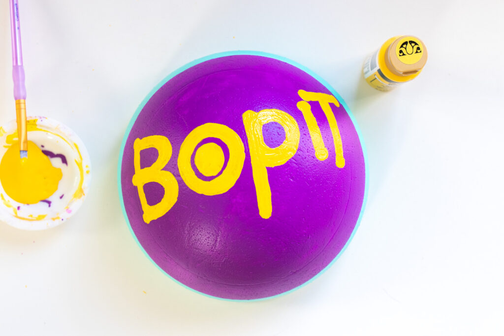 DIY Bop It! Costume // Recreate the classic 90s toy Bop It! with a few simple supplies! This easy 90s toy costume is the perfect nostalgic costume for adults! #costume #halloween #90s #toycostume #adultcostume #halloweencostume #diycostume