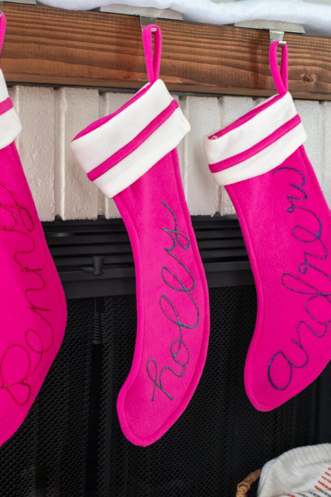 DIY Personalized Calligraphy Stockings // Decorate your mantel with new personalized stockings for the holidays! These DIY calligraphy stockings are easy to recreate with Tulip Dimensional Paints for everyone in your family this Christmas! #christmas #holidaydecor #stocking #stockingdiy #fabricpaint #painting #calligraphy #handlettering