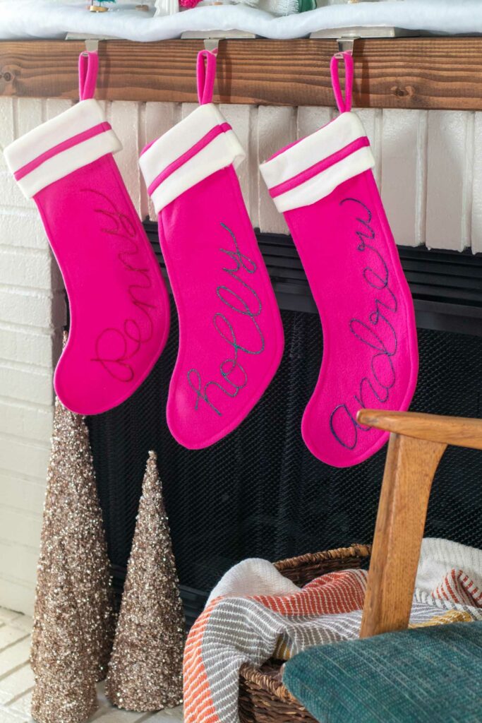 DIY Personalized Calligraphy Stockings // Decorate your mantel with new personalized stockings for the holidays! These DIY calligraphy stockings are easy to recreate with Tulip Dimensional Paints for everyone in your family this Christmas! #christmas #holidaydecor #stocking #stockingdiy #fabricpaint #painting #calligraphy #handlettering