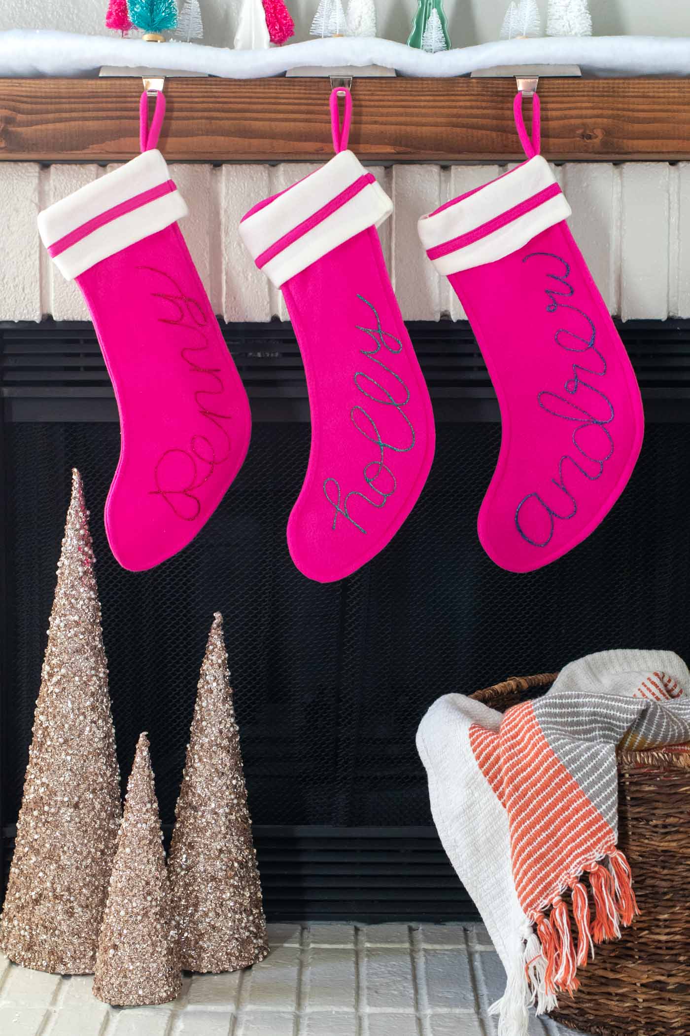 DIY Personalized Calligraphy Stockings // Decorate your mantel with new personalized stockings for the holidays! These DIY calligraphy stockings are easy to recreate with Tulip Dimensional Paints for everyone in your family this Christmas! #christmas #holidaydecor #stocking #stockingdiy #fabricpaint #painting #calligraphy #handlettering