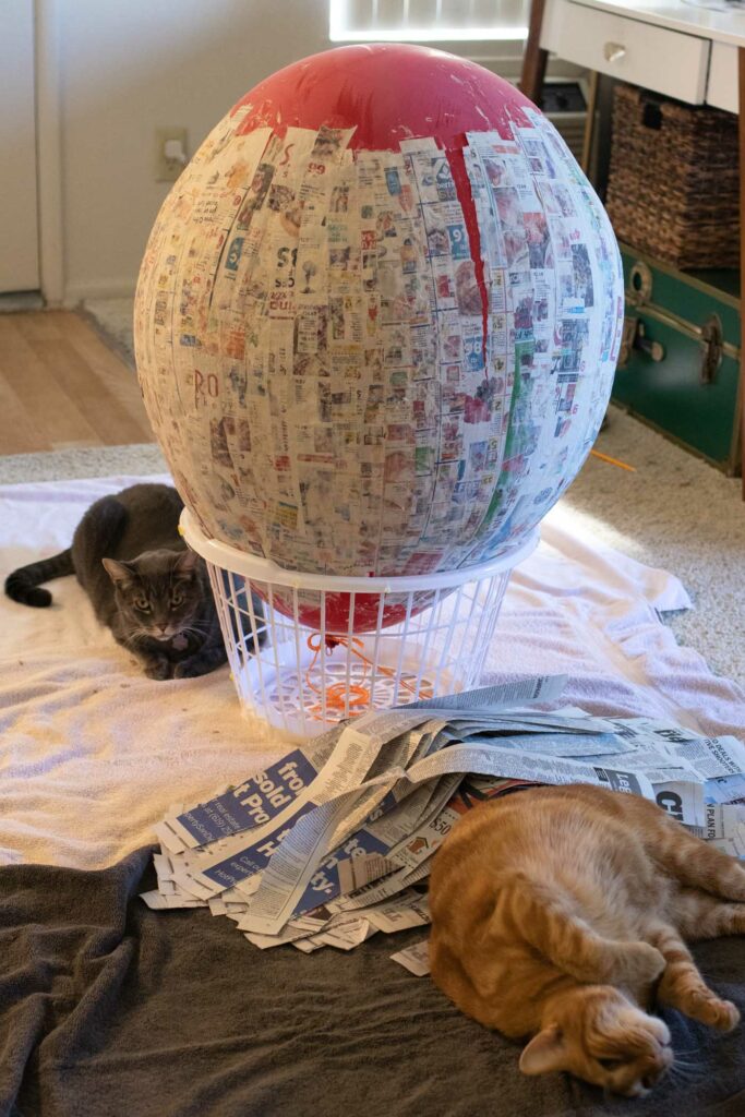 DIY Crystal Ball Costume for Halloween // Use paper mache on a large balloon to create a DIY halloween costume that looks like a mystical crystal ball used by a fortune teller! #crystalball #papermache #halloween #costume #kidscostume #adultcostume