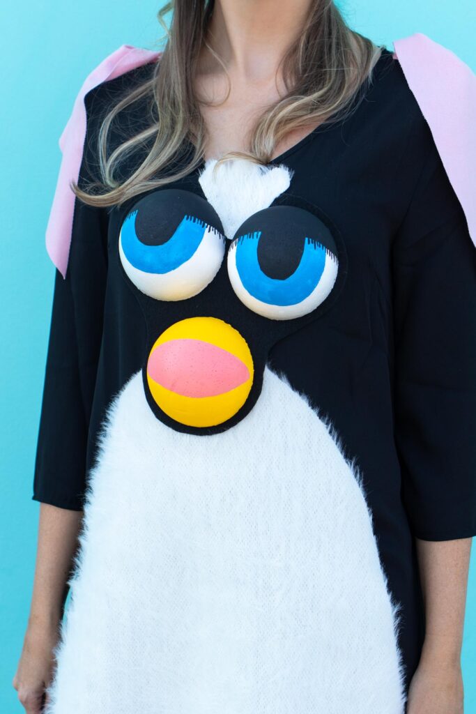 DIY Furby Costume // 90s Toy Costume / Dress up as the classic Furby toy from the 90s with this no-sew Halloween costume! Use faux fur and foam spheres to create a Furby face #halloween #costume #diyhalloween #90s #halloweencostume #furby #dresscostume #nosew