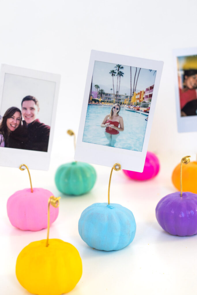 DIY Wire Pumpkin Photo Holders (Place Cards)| Paint mini pumpkins and add wire to create DIY place cards or mini photo holders to decorate for fall and Thanksgiving! #pumpkin #falldiy #falldecor #painting #photoholder #thanksgiving #tablescape #placesetting