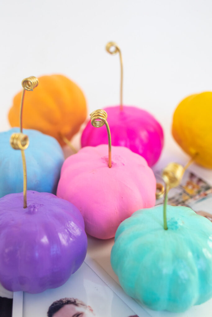 DIY Wire Pumpkin Photo Holders (Place Cards)| Paint mini pumpkins and add wire to create DIY place cards or mini photo holders to decorate for fall and Thanksgiving! #pumpkin #falldiy #falldecor #painting #photoholder #thanksgiving #tablescape #placesetting