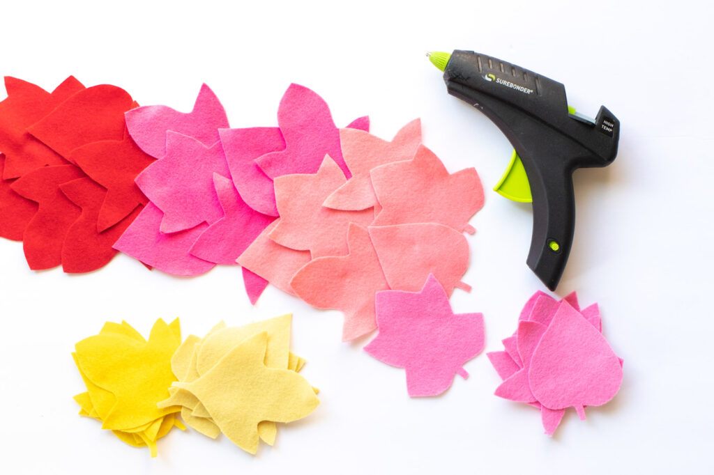 DIY No-Sew Rainbow Leaf Table Runner // Decorate for fall or Thanksgiving with a colorful no-sew table runner made from felt! Cut different leaf shapes to make a rainbow table runner for your dinner table or entryway! #rainbow #diy #entertaining #tablerunner #thanksgiving #thanksgivingdiy #feltcrafts #nosew #rainbowparty #rainbowdecor