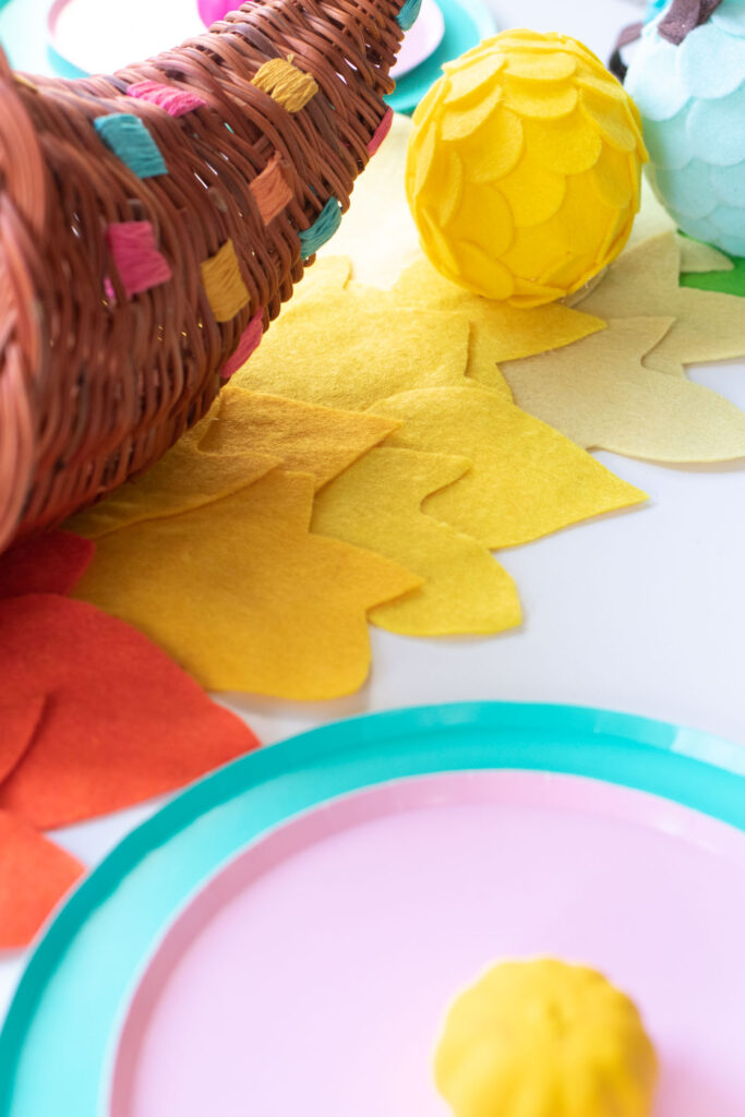 DIY No-Sew Rainbow Leaf Table Runner // Decorate for fall or Thanksgiving with a colorful no-sew table runner made from felt! Cut different leaf shapes to make a rainbow table runner for your dinner table or entryway! #rainbow #diy #entertaining #tablerunner #thanksgiving #thanksgivingdiy #feltcrafts #nosew #rainbowparty #rainbowdecor