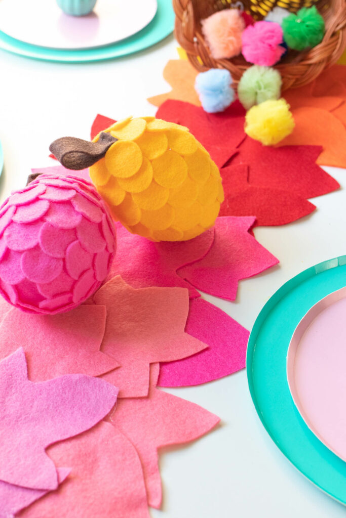 DIY No-Sew Rainbow Leaf Table Runner // Decorate for fall or Thanksgiving with a colorful no-sew table runner made from felt! Cut different leaf shapes to make a rainbow table runner for your dinner table or entryway! #rainbow #diy #entertaining #tablerunner #thanksgiving #thanksgivingdiy #feltcrafts #nosew #rainbowparty #rainbowdecor
