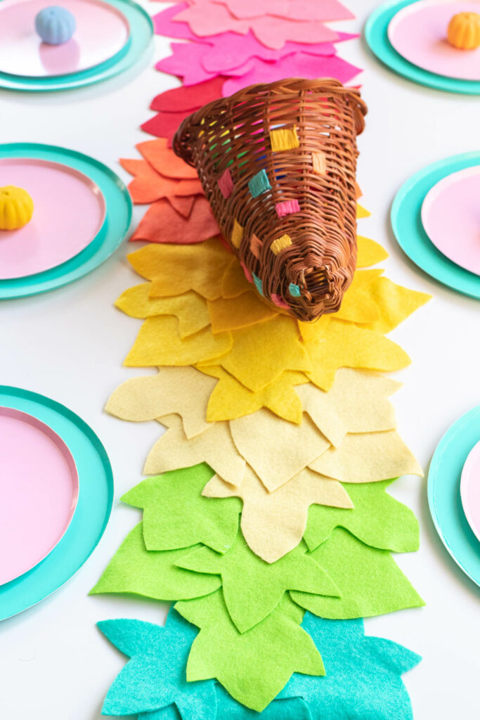 DIY No-Sew Rainbow Leaf Table Runner // Decorate for fall or Thanksgiving with a colorful no-sew table runner made from felt! Cut different leaf shapes to make a rainbow table runner for your dinner table or entryway! #rainbow #diy #entertaining #tablerunner #thanksgiving #thanksgivingdiy #feltcrafts #nosew #rainbowparty #rainbowdecor