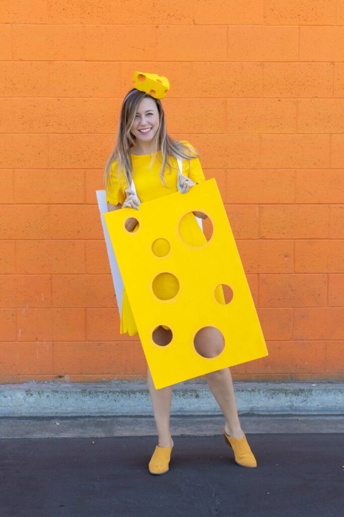 DIY Easy Cheese Costume (Cheeseboard Costume) // Use poster board to make a fun cheesy costume complete with a wedge of cheese headband! This easy last-minute costume is perfect for kids or adults to wear this Halloween #costume #easycostume #diycostume #halloween #adultcostumes #kidscostumes #cheese #posterboard
