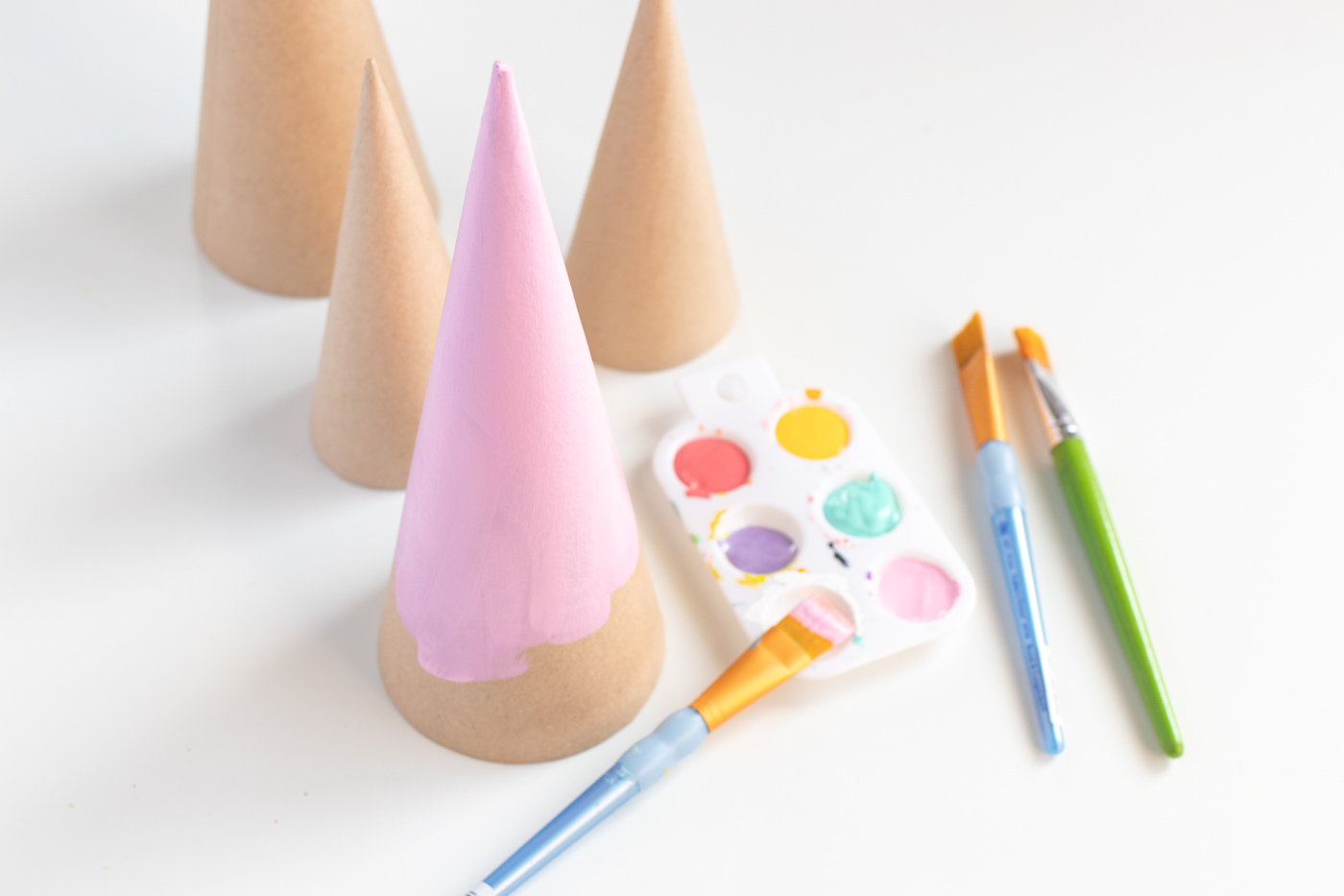 DIY Colorful Rhinestone Tree Decorations // Decorate mache cones with colorful paint and rhinestones to make sparkly tree decorations! These easy DIY Christmas trees make great mantel decor or shelf accessories for the holiday season! #christmasdiy #christmas #christmasdecor #painting #rhinestones #holidaydecor