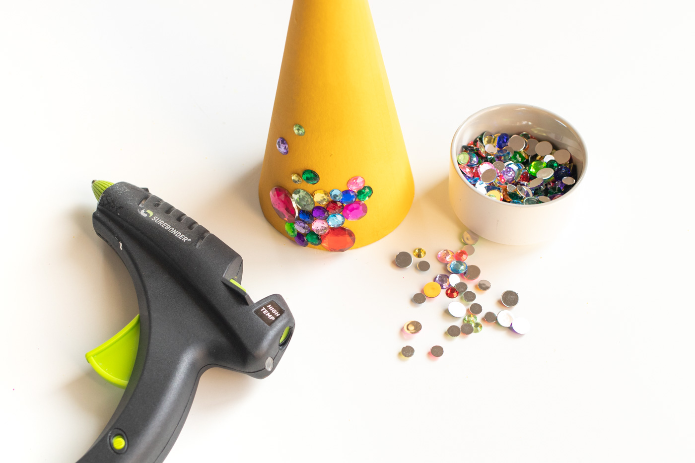 DIY Colorful Rhinestone Tree Decorations // Decorate mache cones with colorful paint and rhinestones to make sparkly tree decorations! These easy DIY Christmas trees make great mantel decor or shelf accessories for the holiday season! #christmasdiy #christmas #christmasdecor #painting #rhinestones #holidaydecor