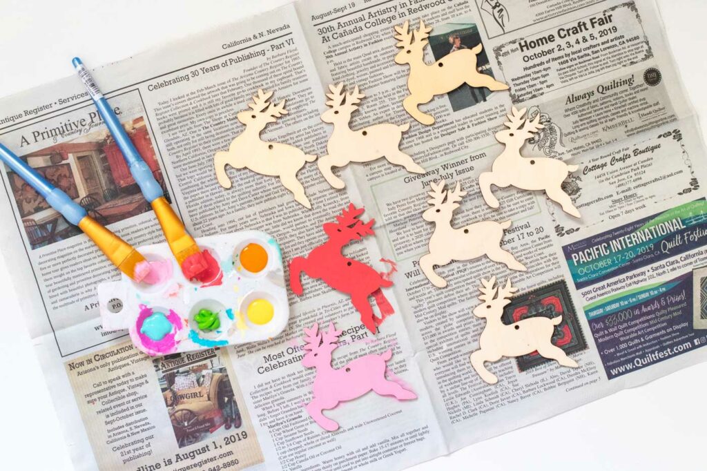 DIY Rainbow Reindeer Garland for Christmas // Paint wooden reindeer ornaments and add holographic vinyl to make a colorful Christmas garland with the names of Santa's reindeer! #christmasdecor #christmas #christmasdiy #rainbowdiy #reindeer #vinyl #cricut #painting