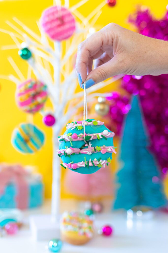 Edible Donut Ornaments // Decorate a Christmas tree or branches with these colorful edible donut ornaments! Display holiday donuts on a tree for a fun party treat or just for a fun weekend project #donuts #holidaydesserts #christmas #christmasfood #christmasparty #partyfood #donutdecorating #candymelts #christmasdecor #diychristmas