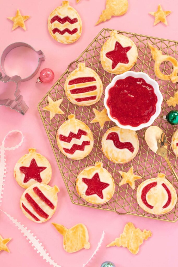 Ornament Pies // Christmas Hand Pies // Cut pie dough into ornament shapes with cut-out details for making cute mini Christmas pies! Fill with colorful cherry pie filling for a great holiday treat or after-dinner Christmas dessert #christmasrecipe #pie #handpies #christmasdessert #pierecipe #cookiecutters #diyornaments
