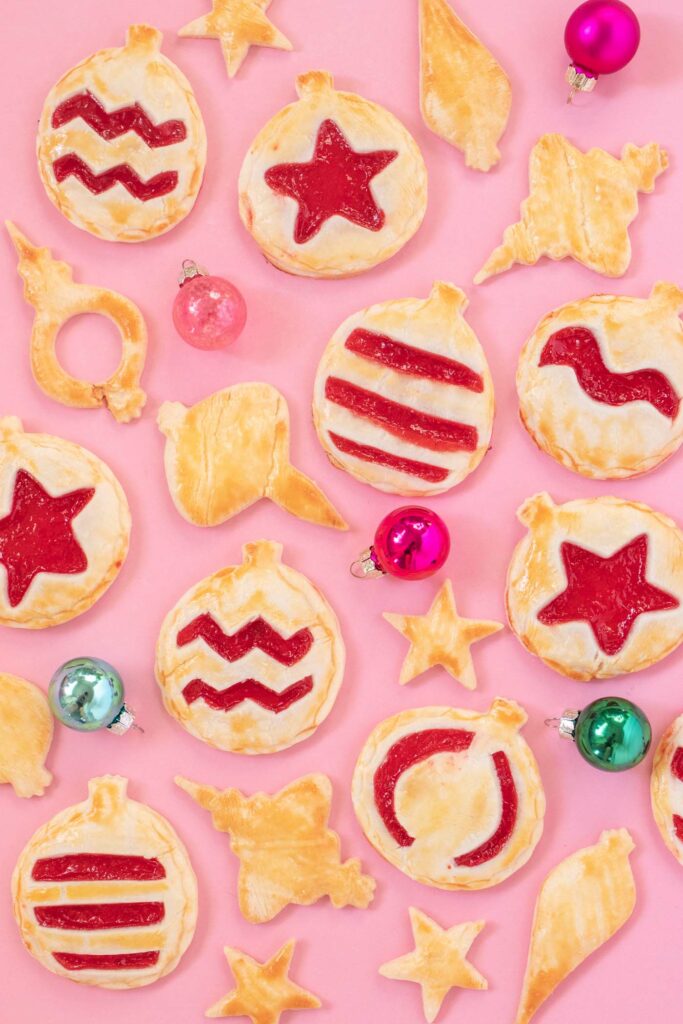 Ornament Pies // Christmas Hand Pies // Cut pie dough into ornament shapes with cut-out details for making cute mini Christmas pies! Fill with colorful cherry pie filling for a great holiday treat or after-dinner Christmas dessert #christmasrecipe #pie #handpies #christmasdessert #pierecipe #cookiecutters #diyornaments