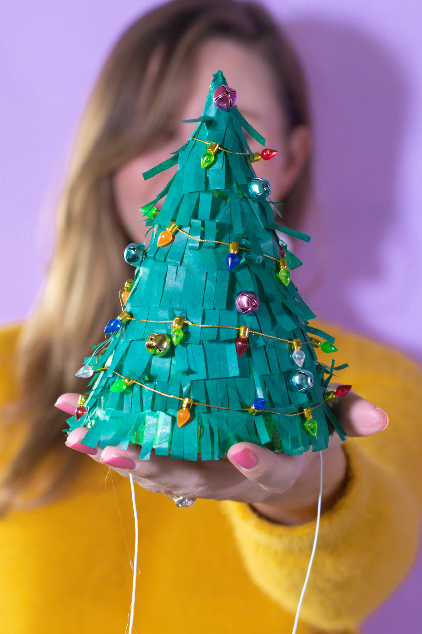 DIY Christmas Tree Party Hats // Turn a plain party hat into a fun holiday craft with tissue paper! Upcycle your hats into fringed Christmas trees decorated with lights and ornaments! #christmas #christmasdiy #christmascrafts #partydiy #partyideas #holidayparty #christmasparty #partyhats