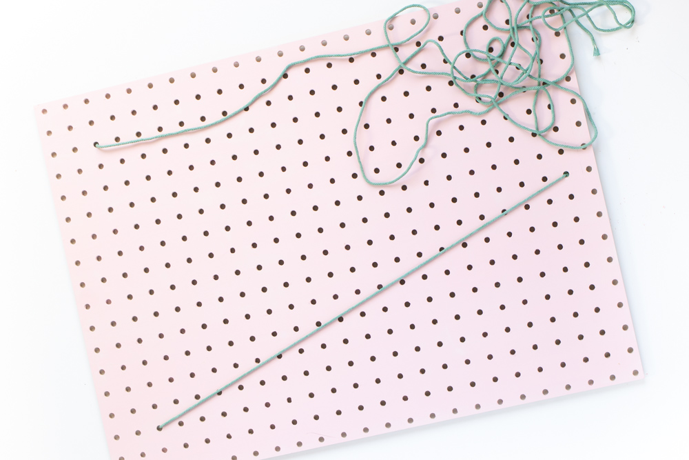 DIY Holiday Pegboard Card Holder // Turn a slab of pegboard into a fun Christmas tree card display inspired by string art! Display your holiday cards in a unique way with this DIY Christmas decor idea #christmasdiy #christmascard #christmasdecor #christmasstorage #pegboard #papercrafts #stringart #holidaystorage #cardstorage
