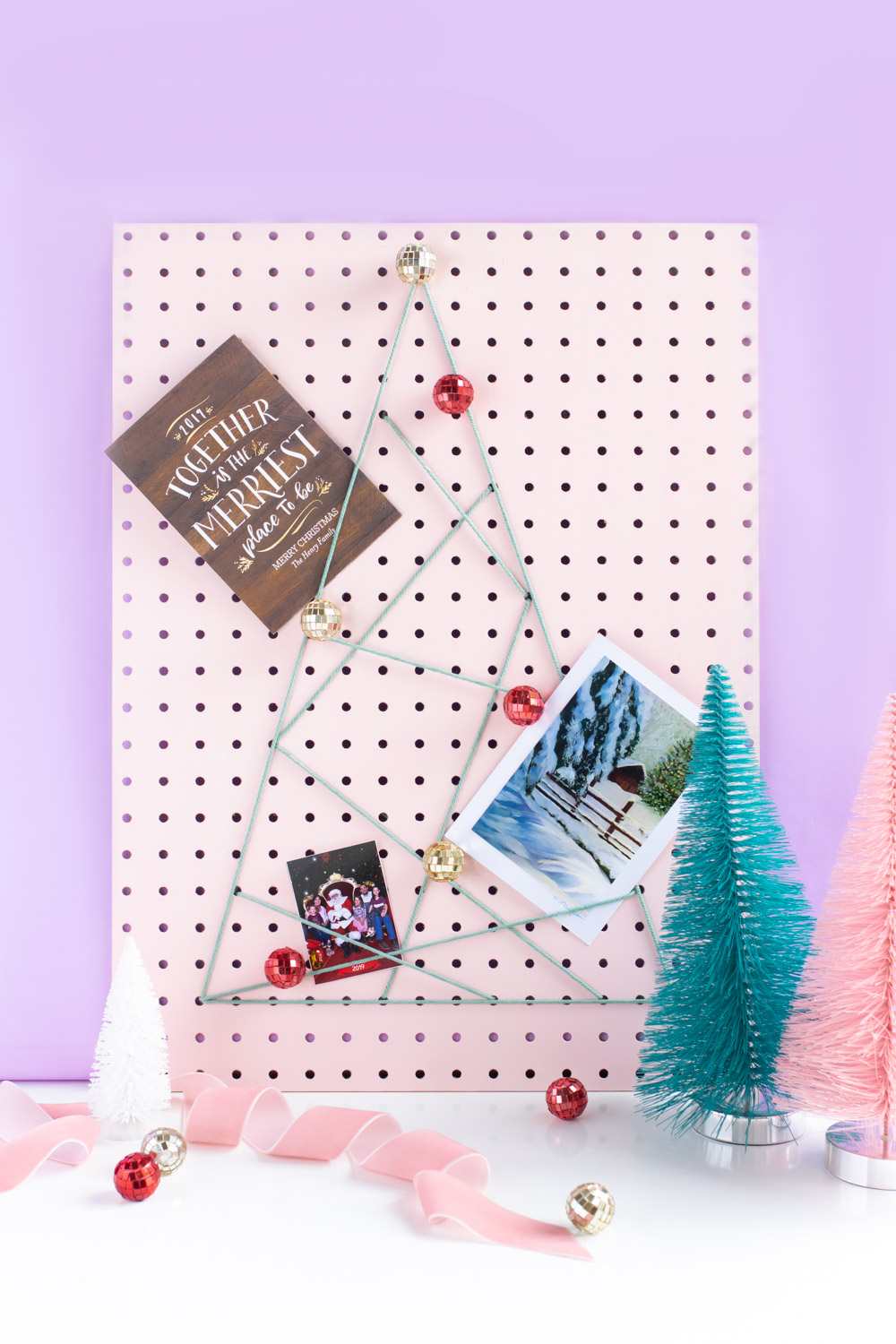 DIY Holiday Pegboard Card Holder // Turn a slab of pegboard into a fun Christmas tree card display inspired by string art! Display your holiday cards in a unique way with this DIY Christmas decor idea #christmasdiy #christmascard #christmasdecor #christmasstorage #pegboard #papercrafts #stringart #holidaystorage #cardstorage