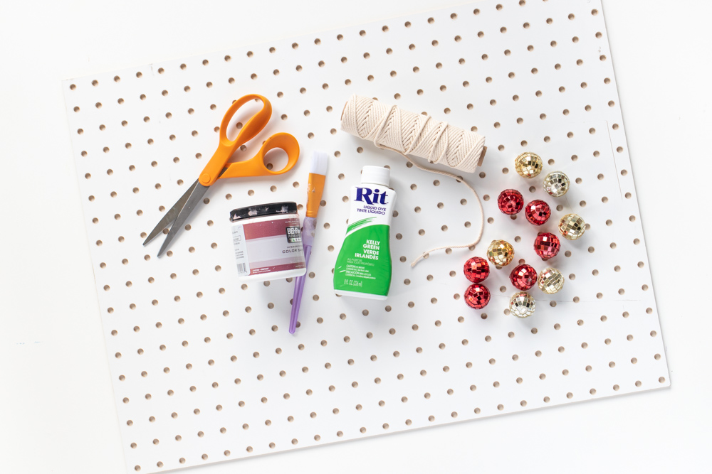 DIY Holiday Pegboard Card Holder // Turn a slab of pegboard into a fun Christmas tree card display inspired by string art! Display your holiday cards in a unique way with this DIY Christmas decor idea #christmasdiy #christmascard #christmasdecor #christmasstorage #pegboard #papercrafts #stringart #holidaystorage #cardstorage