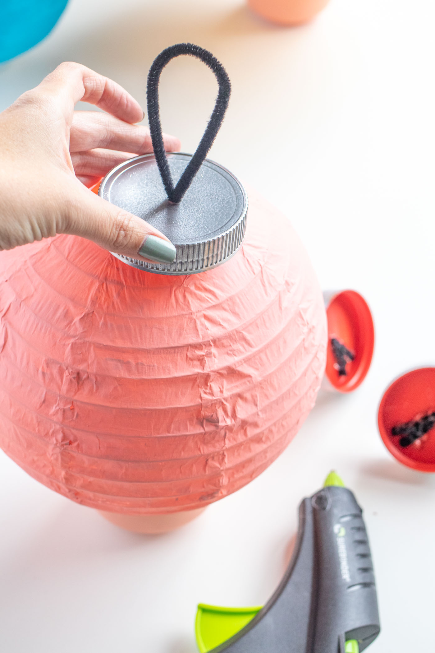 DIY Ornament Lanterns // Turn plain white lanterns into colorful ornament decor with this easy Christmas DIY! Paint lanterns and add tops to make them look like oversized ornaments for your holiday decor! #christmas #christmasdiy #painting #lanterns #papercrafts #homedecor #easydiy #upcycling