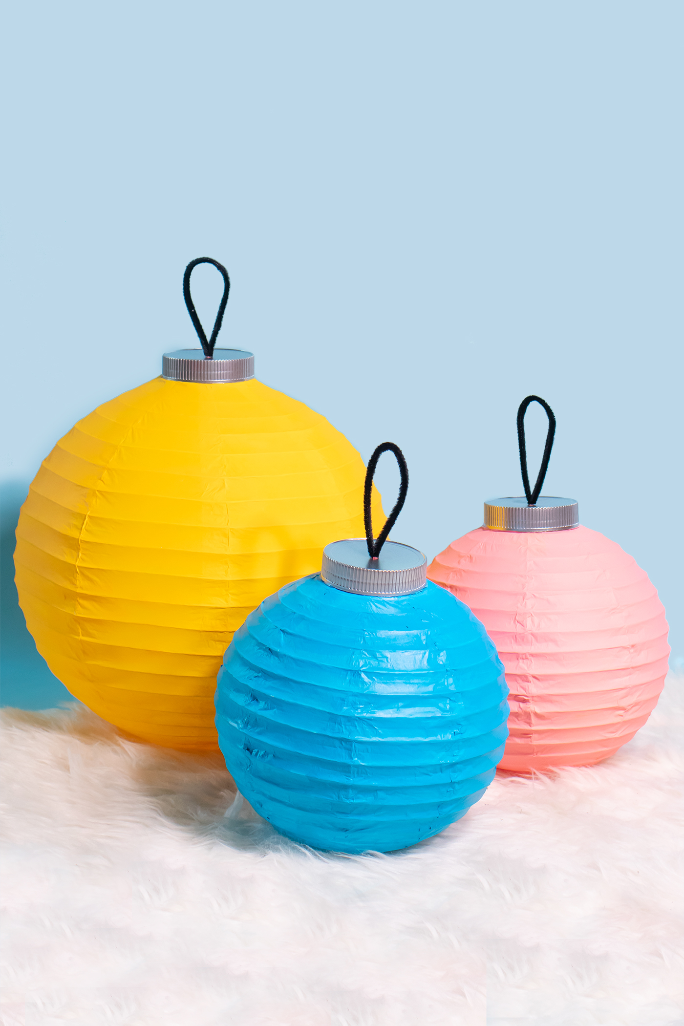 DIY Ornament Lanterns // Turn plain white lanterns into colorful ornament decor with this easy Christmas DIY! Paint lanterns and add tops to make them look like oversized ornaments for your holiday decor! #christmas #christmasdiy #painting #lanterns #papercrafts #homedecor #easydiy #upcycling