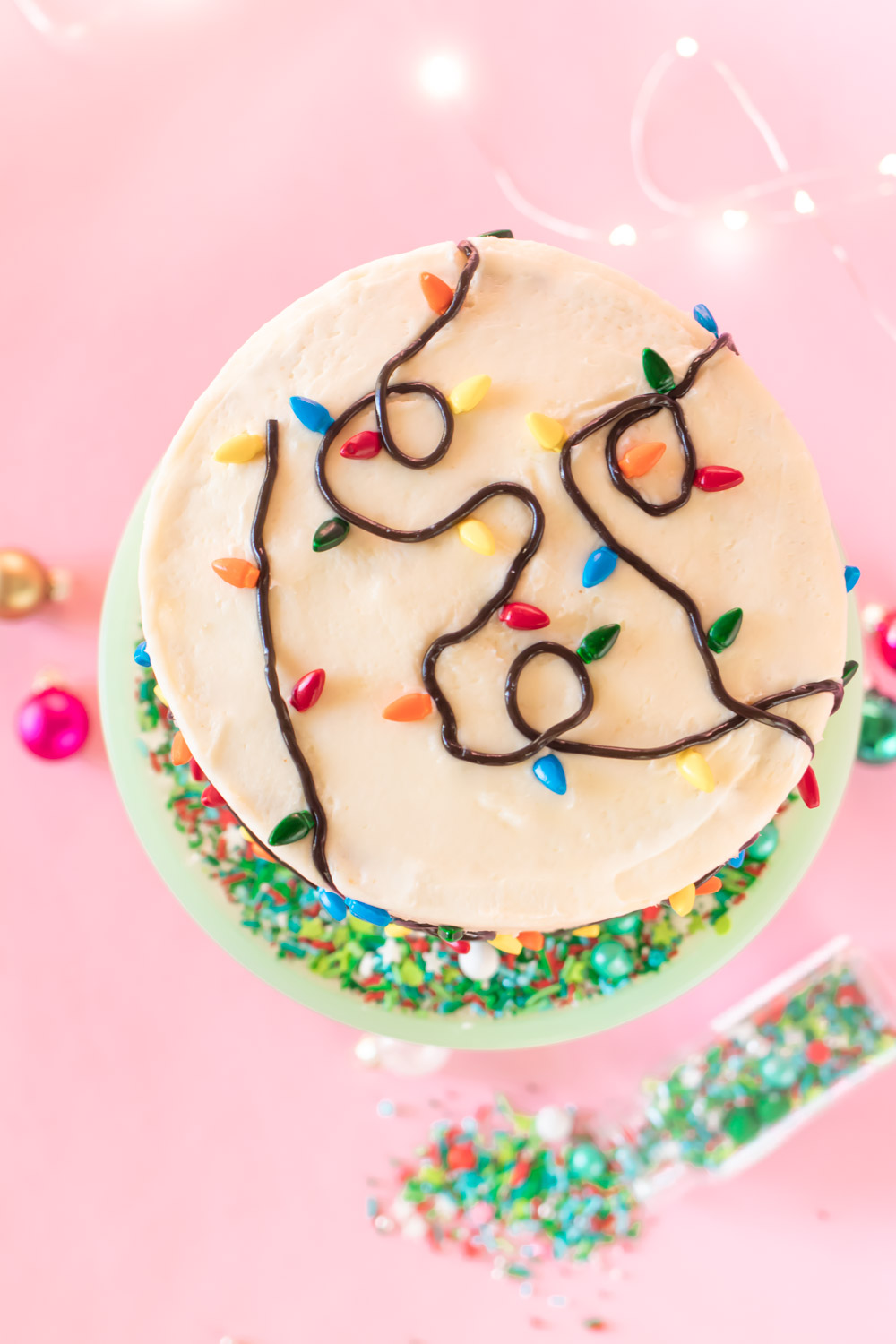 Easy Christmas Light Cake // Make this easy Christmas cake with Wilton sprinkles and licorice strands! Celebrate your holiday party in style with an easy cake decorating idea #christmas #christmasdessert #foodart #cakedecorating #christmasdiy #christmaslights #layercake #christmascake #holidayfood
