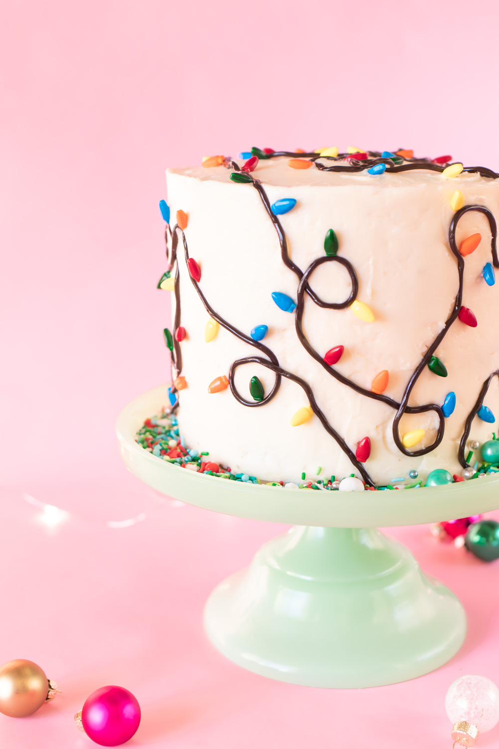 Easy Christmas Light Cake // Make this easy Christmas cake with Wilton sprinkles and licorice strands! Celebrate your holiday party in style with an easy cake decorating idea #christmas #christmasdessert #foodart #cakedecorating #christmasdiy #christmaslights #layercake #christmascake #holidayfood