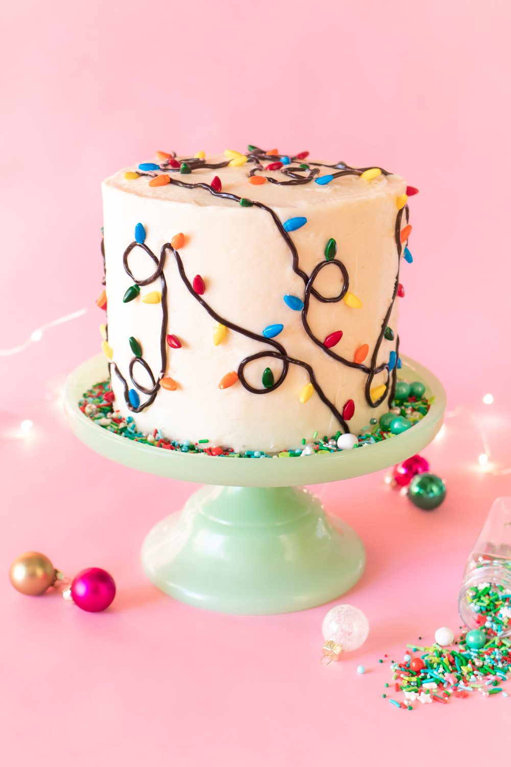 Easy Christmas Light Cake // Make this easy Christmas cake with Wilton sprinkles and licorice strands! Celebrate your holiday party in style with an easy cake decorating idea #christmas #christmasdessert #foodart #cakedecorating #christmasdiy #christmaslights #layercake #christmascake #holidayfood
