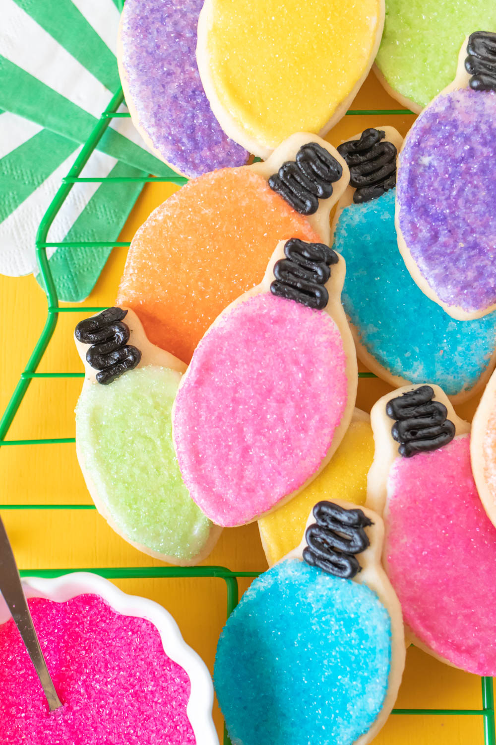 Easy Christmas Light Cookies with Sprinkles // Decorate sugar cookies to look like Christmas lights in different colors! Use sugar crystal sprinkles and black icing to create colorful light cookies for celebrating Christmas! #christmas #christmascookies #sugarcookies #sprinkles #cookierecipes #cookiedecorating #christmasdesserts #cookieswap