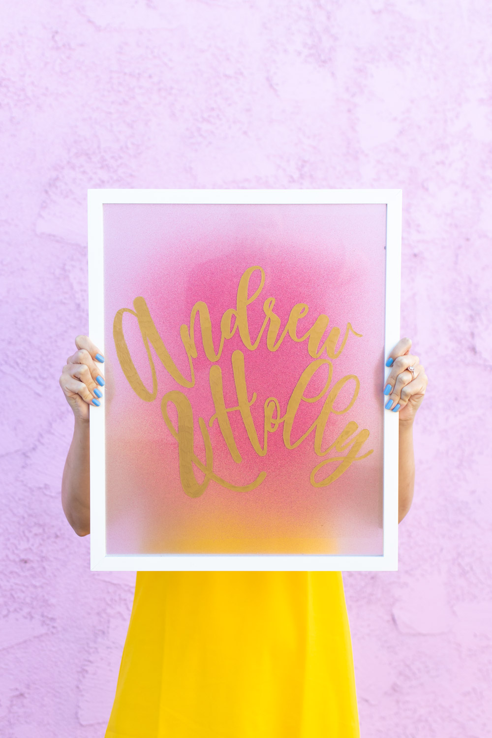 Easy DIY Calligraphy Wedding Sign // Use a large photo frame to make your own custom wedding signage with @rustoleum spray paints! Trace your names or sayings, then let it pop off the glass with the new Imagine collection of glitter spray paint available at @joann! #joannpartner #prideinthemaking #weddingdiy #diywedding #weddingsign #spraypainting #calligraphy #diyideas #homedecor