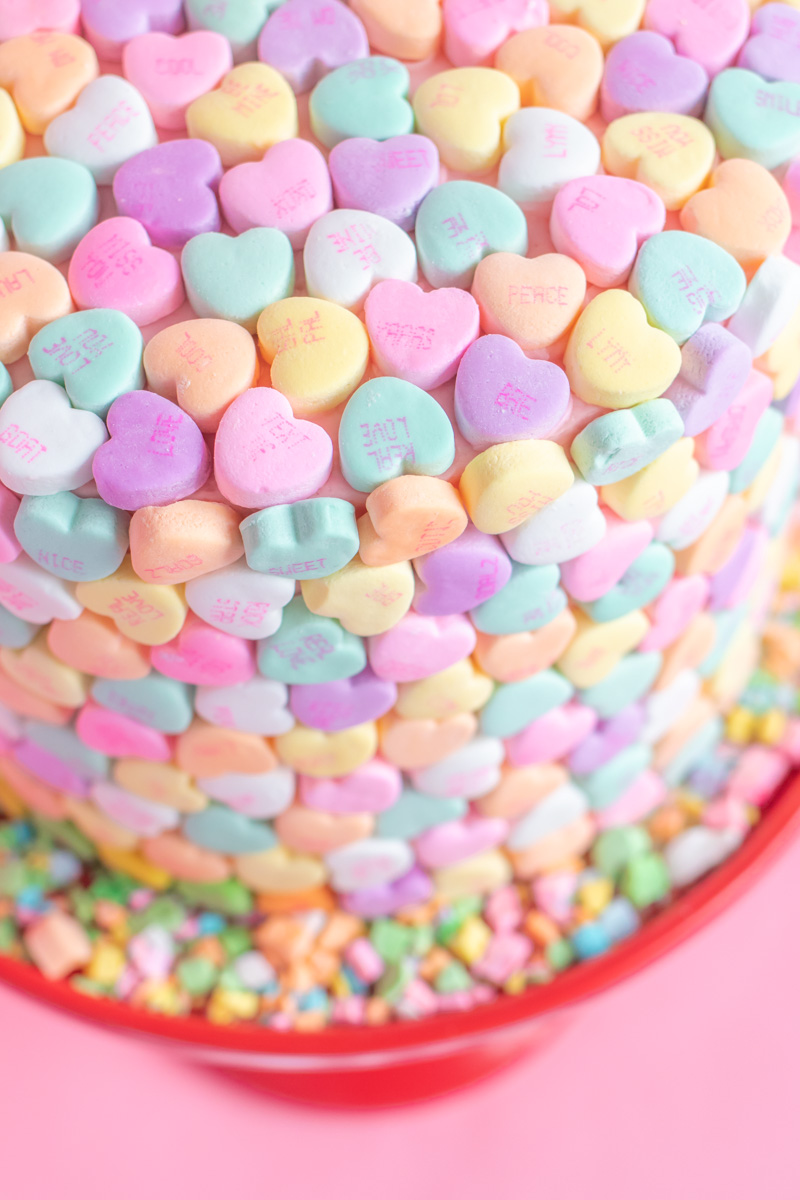 Valentine's Day Cake Idea // Conversation Heart Cake // This easy V-Day cake is as simple as using mini heart candies to cover the cake for a perfect Valentine's Day dessert! #cakedecorating #cakeideas #cakerecipes #valentinesday #galentinesday #valentinesdaydessert