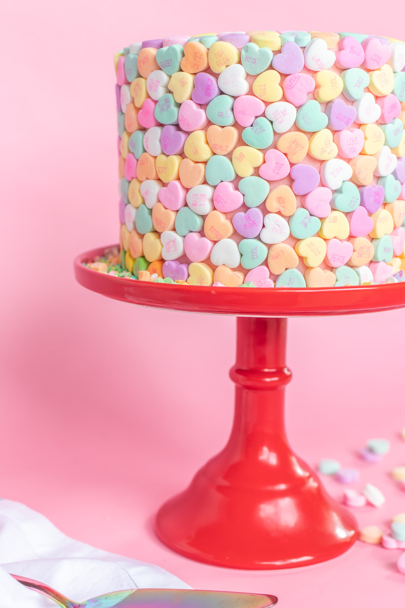 Valentine's Day Cake Idea // Conversation Heart Cake // This easy V-Day cake is as simple as using mini heart candies to cover the cake for a perfect Valentine's Day dessert! #cakedecorating #cakeideas #cakerecipes #valentinesday #galentinesday #valentinesdaydessert