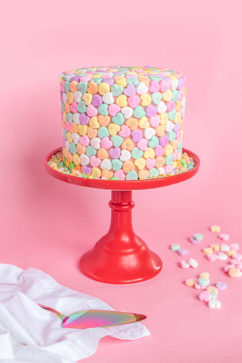 Valentine's Day Cake Idea // Conversation Heart Cake // This easy V-Day cake is as simple as using mini heart candies to cover the cake for a perfect Valentine's Day dessert! #cakedecorating #cakeideas #cakerecipes #valentinesday #galentinesday #valentinesdaydessert