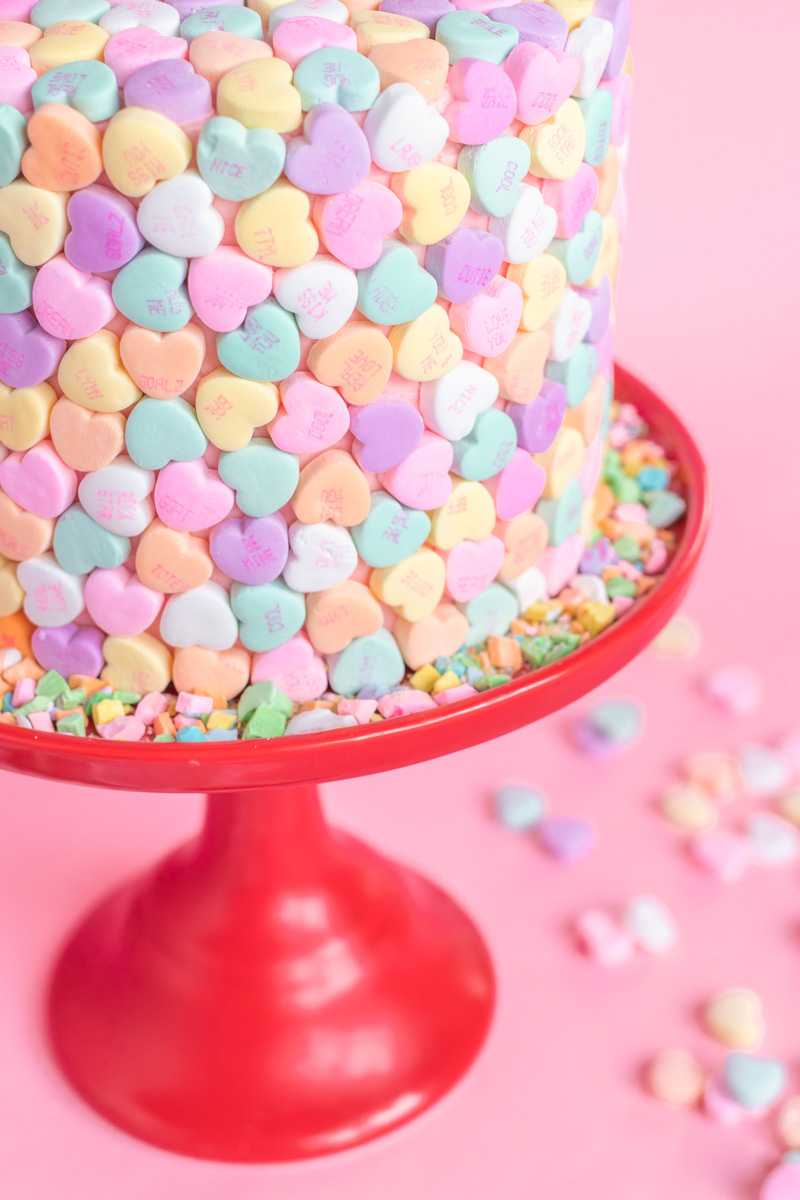 Valentine's Day Cake Idea // Conversation Heart Cake // This easy V-Day cake is as simple as using mini heart candies to cover the cake for a perfect Valentine's Day dessert! #cakedecorating #cakeideas #cakerecipes #valentinesday #galentinesday #valentinesdaydessert
