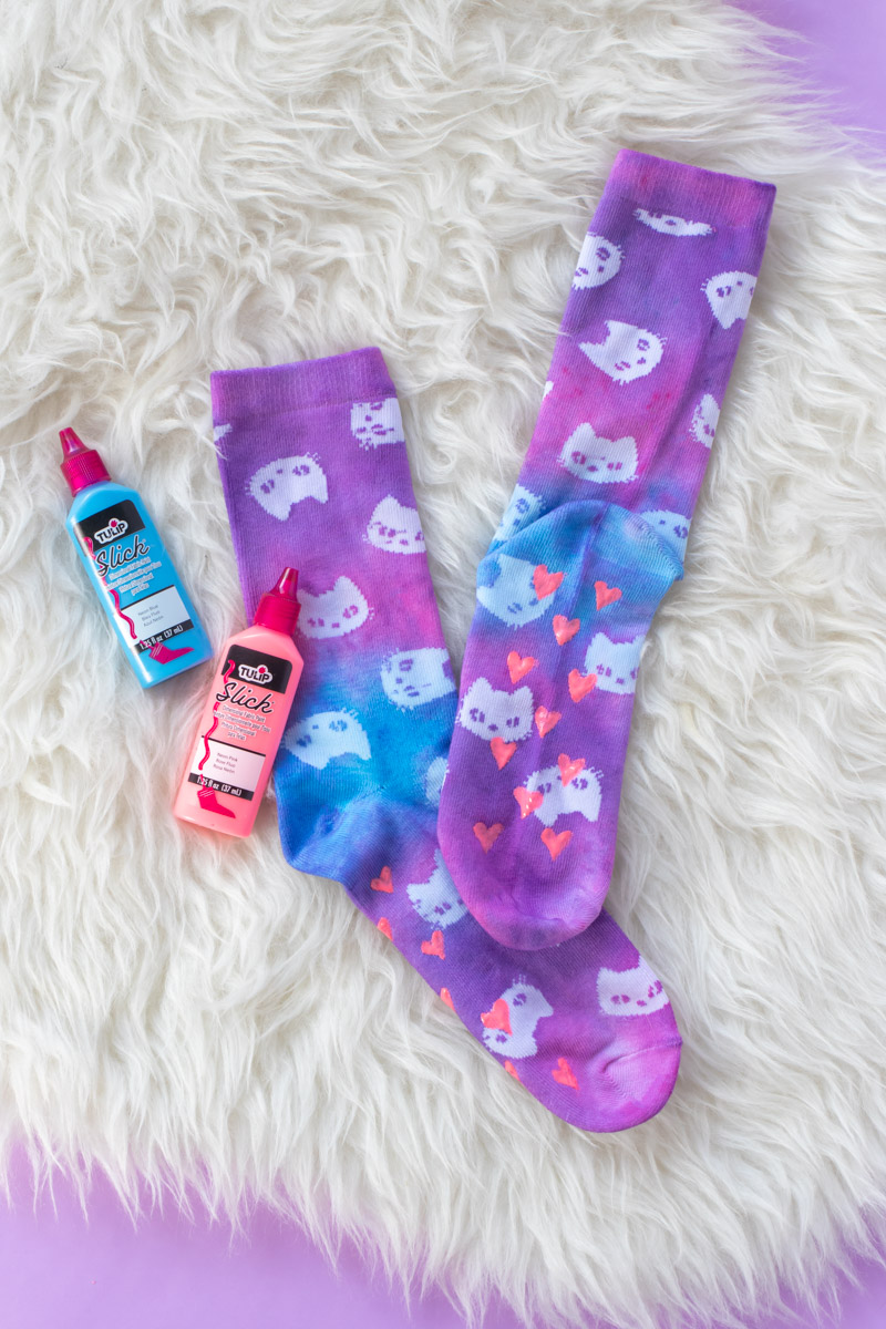 DIY Tie Dye Grip Socks // These easy DIY tie dye socks are the perfect craft for teens and young adults! Use a Tulip kit to make these colorful socks with painted neon grip for no-slip socks everyone needs #ad #tiedye #dyeing #nosew #painting #fabricpaint #kidscrafts #diysforteens #craftsforteens #teencrafts #slumberparty